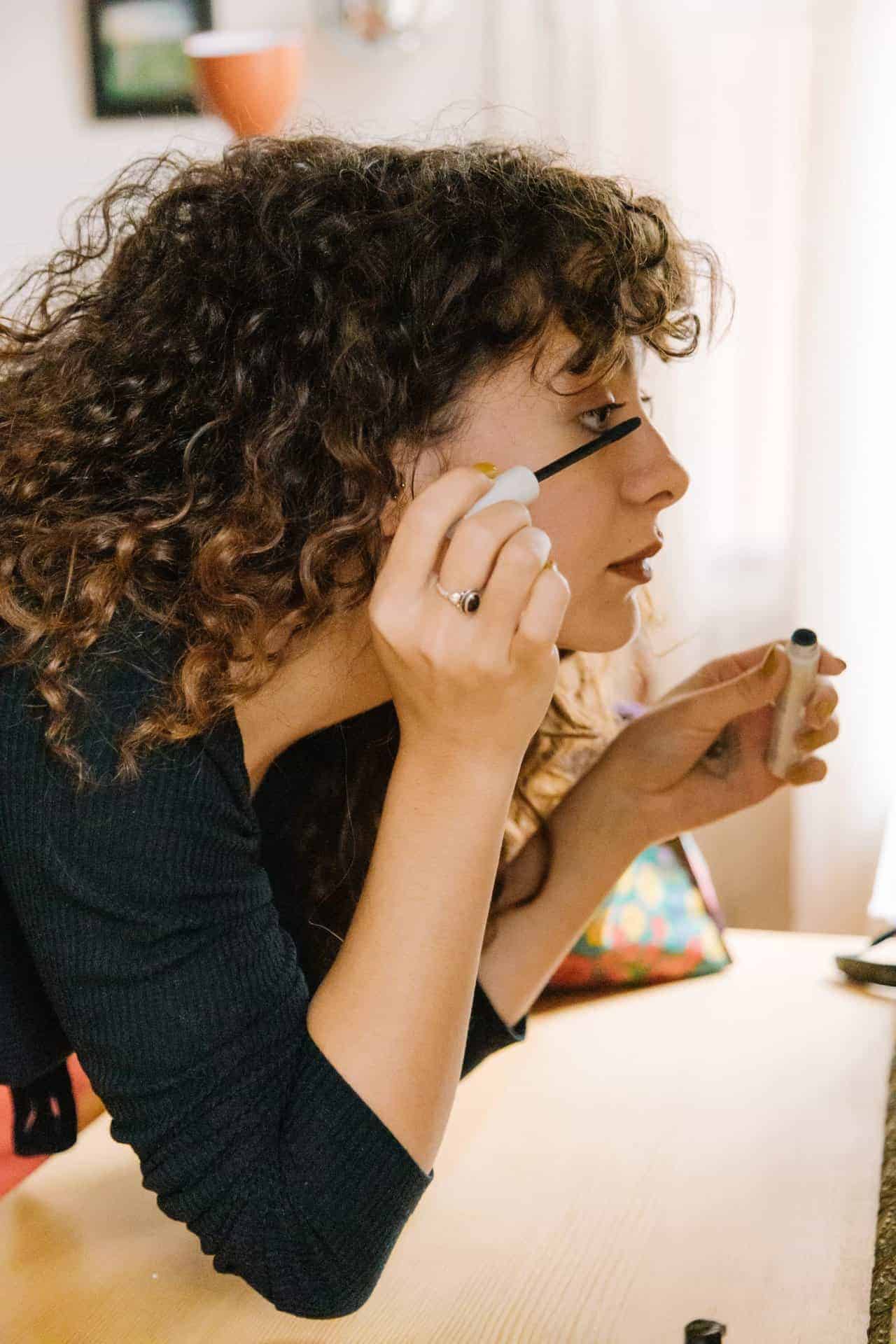 Woman putting on mascara