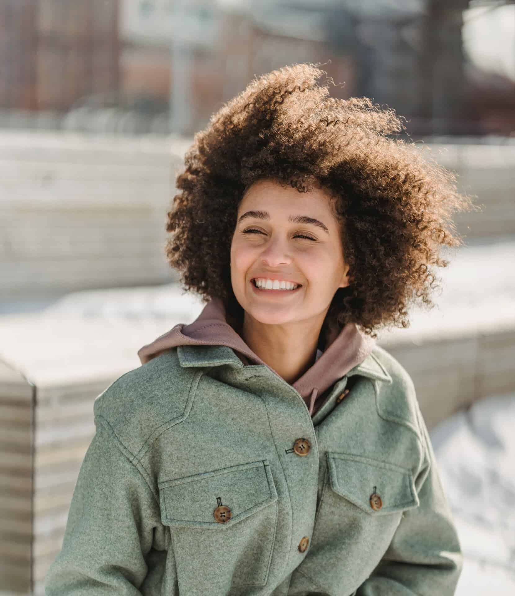 Woman smiling with hair blowing in wind